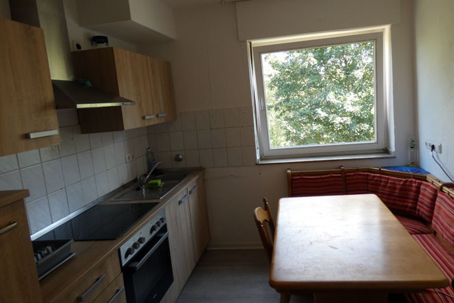 Die Küche in Krefeld mit Küchenzeile, Tisch und Fenster.